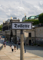 Tourist city of Dresden, Germany. City center, sign in old German "toilet" Focus on the sign, background out of focus
