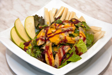 Pear and vegetable salad with mango and strawberry dressing, fresh green salad