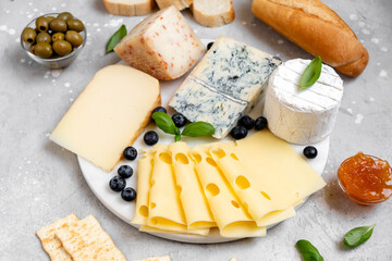 Cheese platter with craft cheese assortment on a marble platter. hard cheeses, mold cheese,...