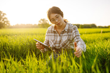 Smart farm. Woman Farmer with tablet in green field. Agriculture, gardening, business or ecology...