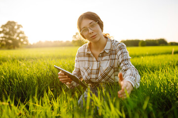 Smart farm. Woman Farmer with tablet in green field. Agriculture, gardening, business or ecology...