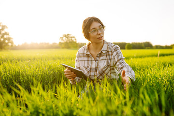 Smart farm. Woman Farmer with tablet in green field. Agriculture, gardening, business or ecology concept.