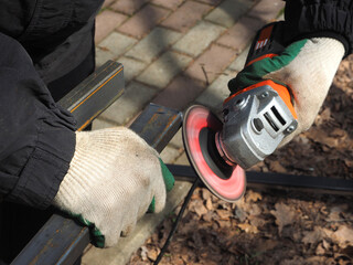 A worker processes metal with an angle grinder on a construction site.
The concept of locksmith...