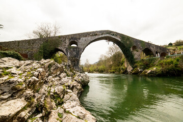 Roman bridge in the town of Cangas de Onis, Asturias, Spain - 784770363