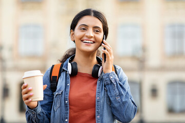 Indian student talking on phone with coffee