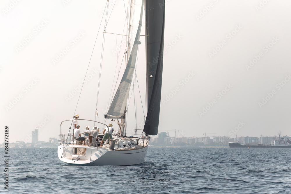 Wall mural serene view of a sailboat participating in a yachting regatta, with the calm mediterranean sea as th