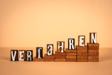 Procedure word in German. Wooden alphabet letters on a light background