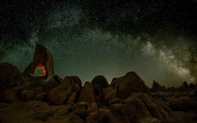 Aced Galaxy milky way surrounded by starswith a hollowed rock on foreground	