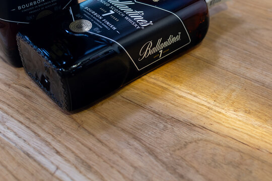 Bottle of blended scotch whisky Ballantine's 7 years aged Bourbon Finish close-up on oak cask. Ukraine, Zhytomyr, April, 10, 2024