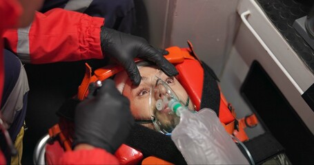 Man, patient and paramedic in first aid with flashlight, eyes and emergency with medicine and injured. Victim, accident and ems of 911 with oxygen mask, medical service and healthcare to hospital