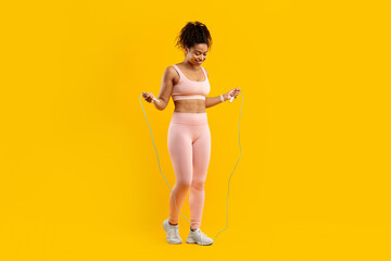 Lady with jump rope on a bright yellow background