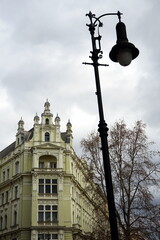 Prachtvoller Altbau und Eckhaus im Jugendstil in Naturfarben und alte Straßenlaterne bei Regenwetter mit Regenwolke im jüdischen Viertel Josefov in der Altstadt von Prag an der Moldau in Tschechien