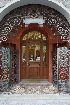 Prachtvoller alter Hauseingang mit spiegelndem Glas, edler Holzt&uuml;r und kunstvollem Schmiedeeisen im Jugendstil des restaurierten Altbau im j&uuml;dischen Viertel im Stadtteil Josefov in Prag in Tschechien
