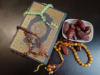 Top details of holy book, with rosary and dates. 