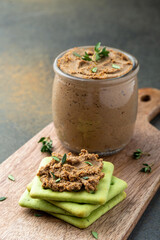 Fresh homemade liver pate served with herb crackers on wooden board