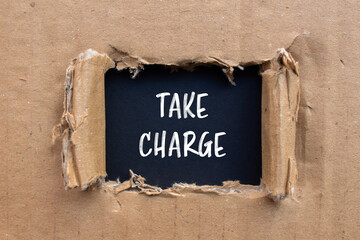 Take charge words written on ripped paper with black background. Conceptual take charge symbol. Copy space.