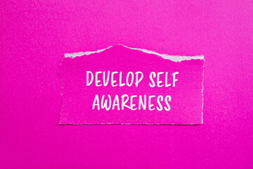 Develop self awareness words written on ripped paper with pink background. Conceptual symbol. Copy space.