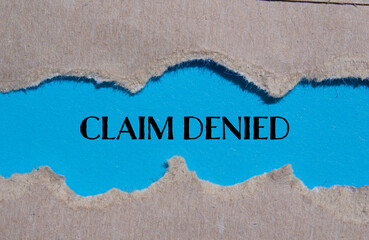 Claim denied words written on ripped paper with blue background. Conceptual symbol. Copy space.