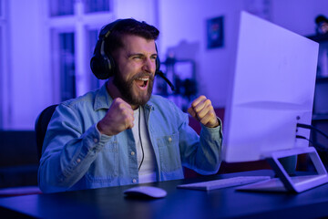 Man cheering during gaming session at PC