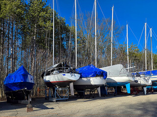 Row of boats with protective covering in an outdoor storage lot - 784784345