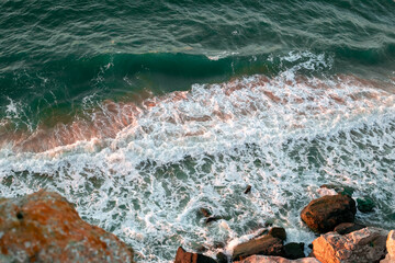 stormy sea with waves hitting the rocky shore, view from above. Seascape.