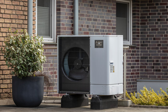 Mitsubishi Luft-Wasser-Wärmepumpe Zubadan mit K#ältemittel R32 vor einem Mehrfamilienhaus