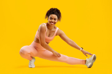 Energetic black woman doing a fitness side lunge - obrazy, fototapety, plakaty