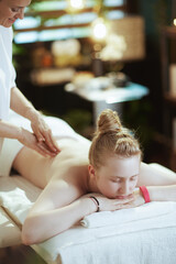 female massage therapist in massage cabinet making massage