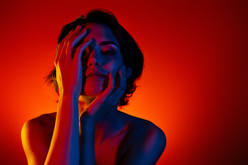 Photo of pretty adorable woman naked shoulders arms applying lotion empty space isolated red neon...