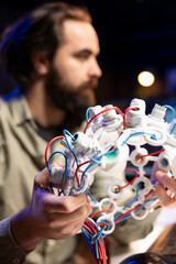 Focus on EEG headset used by IT professional in blurry background to communicate with artificial...