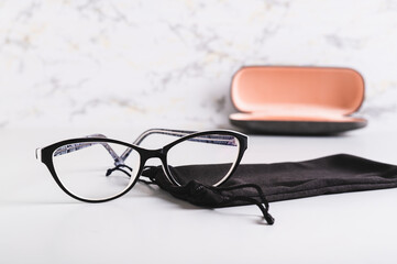 Eyeglasses on a soft case against the background of a hard case on the table