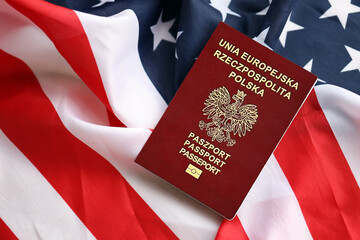 Poland passport on United States national flag background close up. Tourism and diplomacy concept