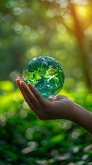 Hand holding world ball on green bokeh background, world earth day
