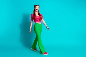 Foto op Aluminium Full length photo of adorable pretty lady dressed pink knitted shirt walking emtpy space isolated blue color background © deagreez