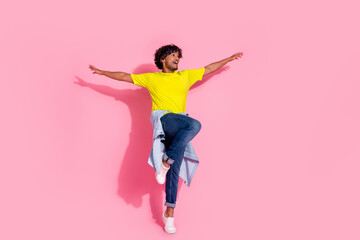 Photo of positive funky nice man wear trendy yellow clothes look empty space raise arms isolated on...