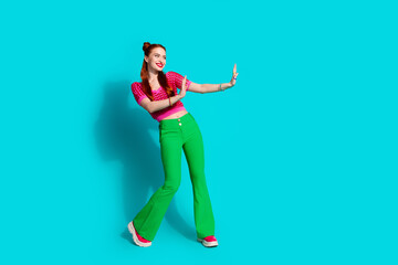 Fototapeta na wymiar Full length photo of cheerful funky lady dressed pink knitted shirt showing arms emtpy space isolated blue color background