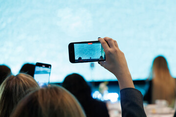 close-up of a girl shooting video on her phone at an event
