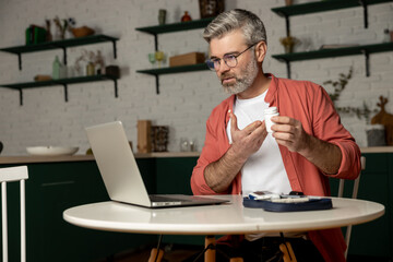 Diabetic man getting online consultation on laptop at home