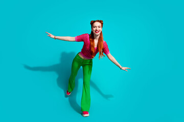 Obraz premium Full length photo of excited funky lady dressed pink knitted shirt having fun emtpy space isolated blue color background