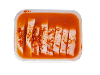Raw pork chops in plastic container with red liquid marinade. Uncooked meat preparation. Isolated white background.
