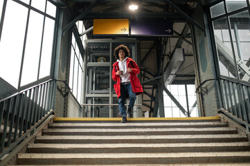 Traveler in red jacket on the steps of the railway station