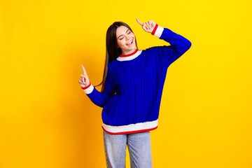 Photo portrait of pretty teen girl dancing have fun wear trendy knitwear blue outfit isolated on yellow color background