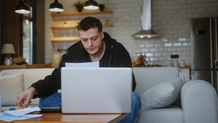 Man feeling worried about financial problem doing paperwork, work on laptop. Stressed entrepreneur...