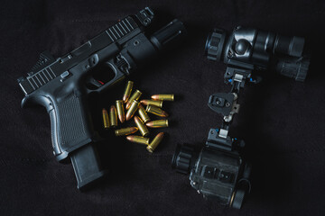 Military night vision device and tactical pistol with flashlight and red dot and 9mm cartridges.