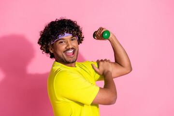Photo of positive strong nice man wear trendy yellow clothes showing muscular arm triceps isolated...