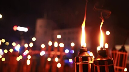 A gathering in Riga, with red candle holders illuminating the scene, signifies a respectful commemoration of Independence Day in Latvia near the castle of Riga.