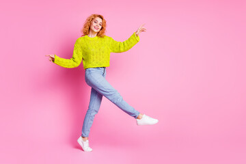Fototapeta na wymiar Full length photo of good mood pretty cheerful girl wear green stylish clothes walk empty space isolated on pink color background