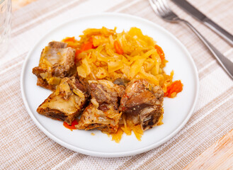 Home style stew of cabbage with carrots and chopped pork ribs. Traditional Ukrainian cuisine