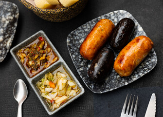 Juicy grilled creole sausages served with pickled vegetables