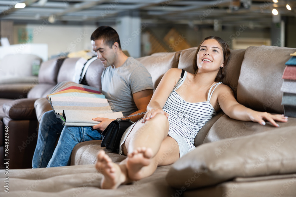 Sticker boyfriend and girlfriend are choosing color of new sofa in furniture store